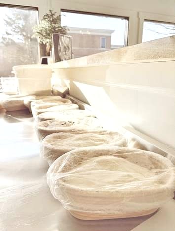 Dough proofing in covered cane baskets along the bakery window